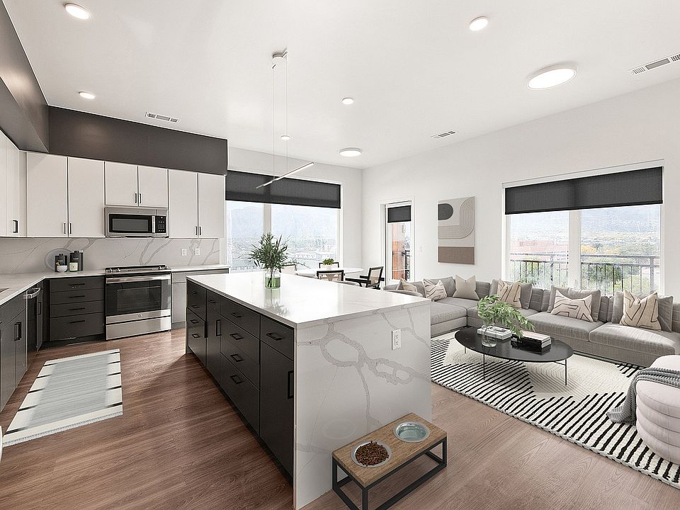 Modern open-concept kitchen and living area with sleek cabinetry, a spacious island, and panoramic window views.