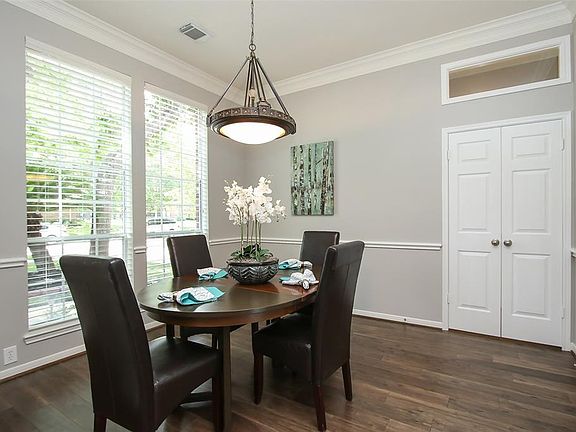 The Elegant Dining Room features Double Crown Molding, Chair Rail, Transom Window, Updated Chandelier and 3" Beveled Blinds.