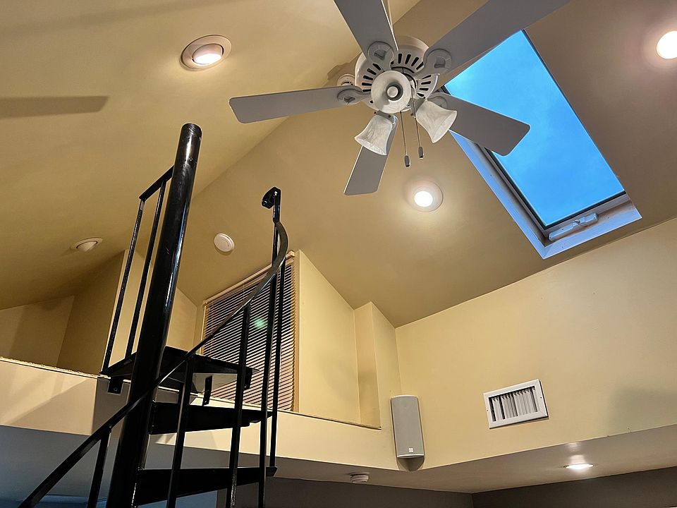 View of spiral staircase up to loft with new ceiling fan.