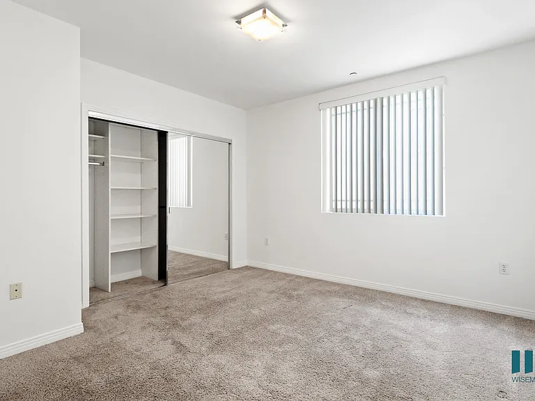 Bedroom with Closet with Shelving, Carpet, and Window