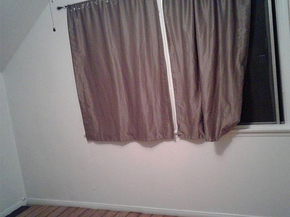 smaller of the two rooms upstairs with floor and window