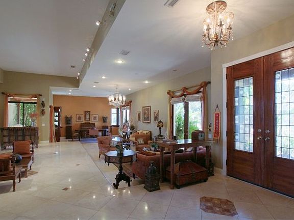 Volume ceilings, travertine floors, and French doors to the veranda.