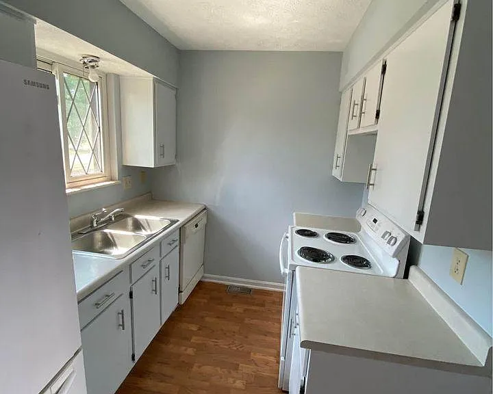 The kitchen is equipped with a stove and over, fridge, and dishwasher