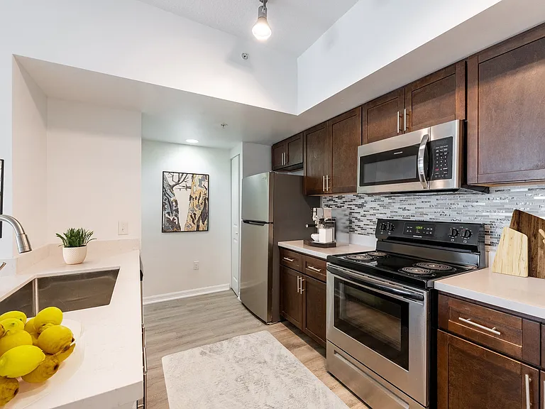 Gourmet kitchens feature granite countertops and tile backsplash in select apartments.
