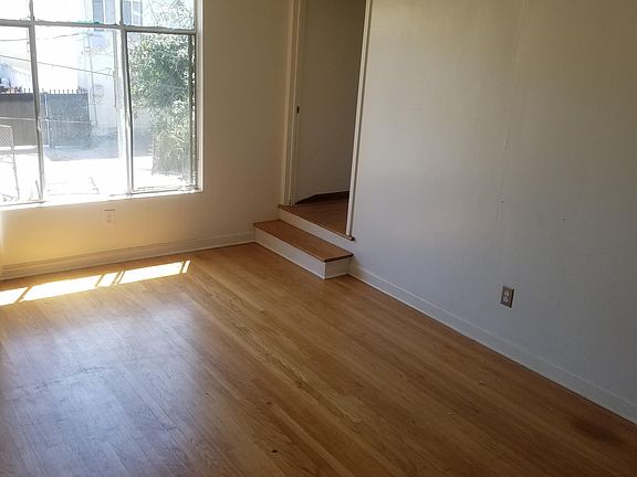 Living room gets great light and awesome ocean breeze. New white vertical blinds, too!