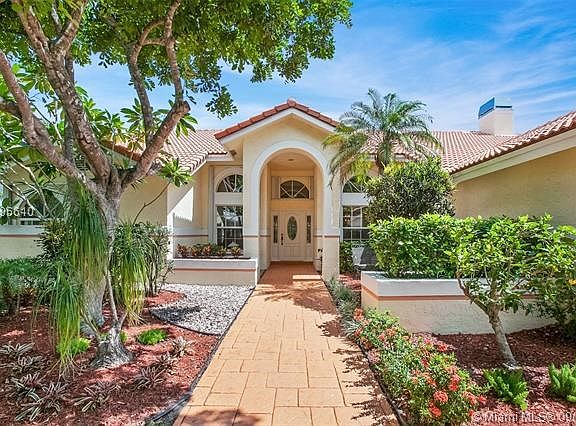 Grand foyer entrance and walkway to glass decorative front door- barrel tile roof and accordian hurricane shutters