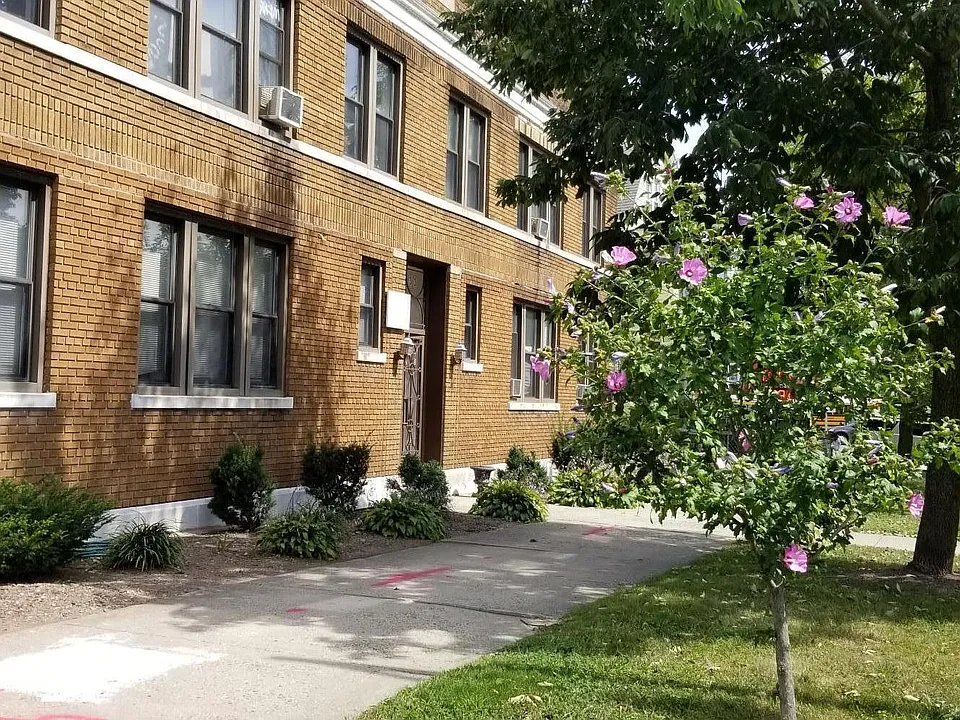 Front of building with summer landscaping and flowers. Improvements underway!