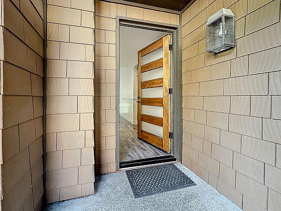 Enter into 59 Sea Pine -- new wood panel and glass front door, new flooring throughout