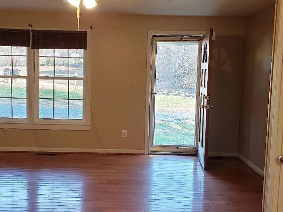 Livingroom with hardwood flooring, view of cow pasture.