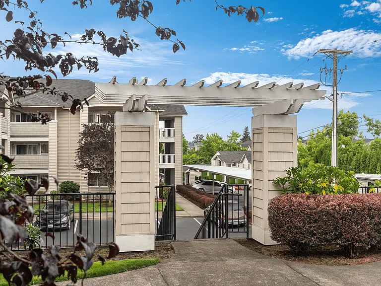Community courtyard entrance with pergola and landscaped surroundings