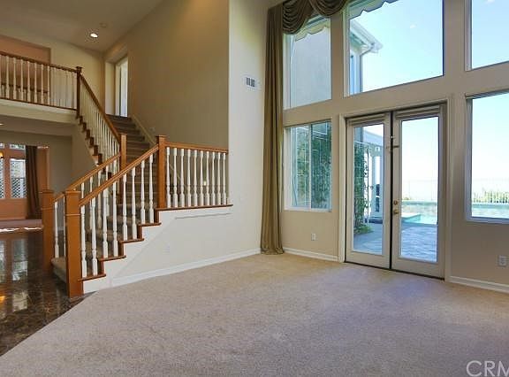 Another view of the living room looking toward the view over the pool and toward the stairs, hall and dining room.