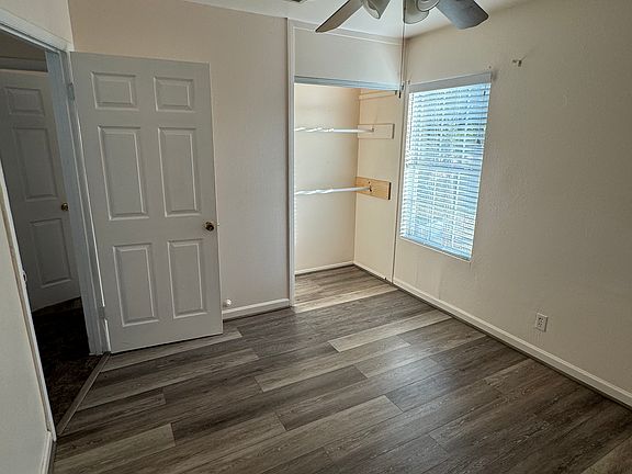 Bedroom with LVP flooring, ceiling fan and closet