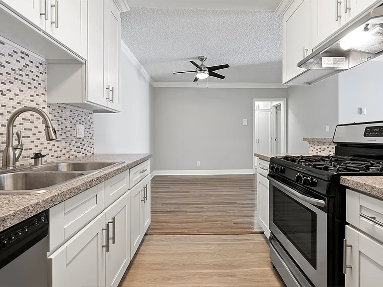 Custom tiled kitchen with stainless steel sink, oven, and fixtures.
