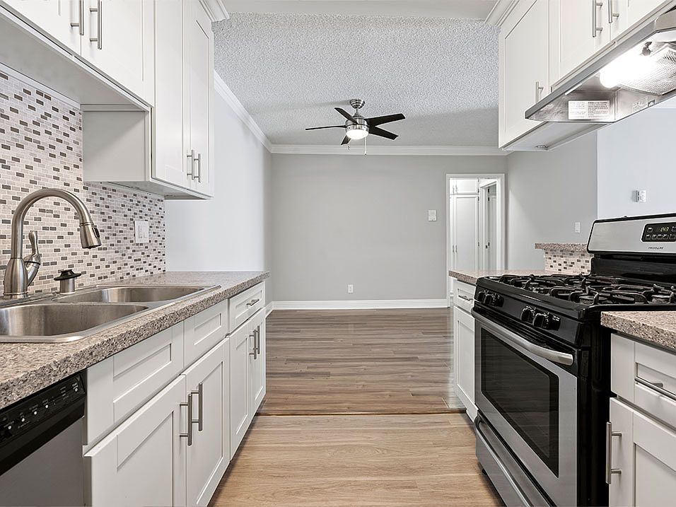 Custom tiled kitchen with stainless steel sink, oven, and fixtures.