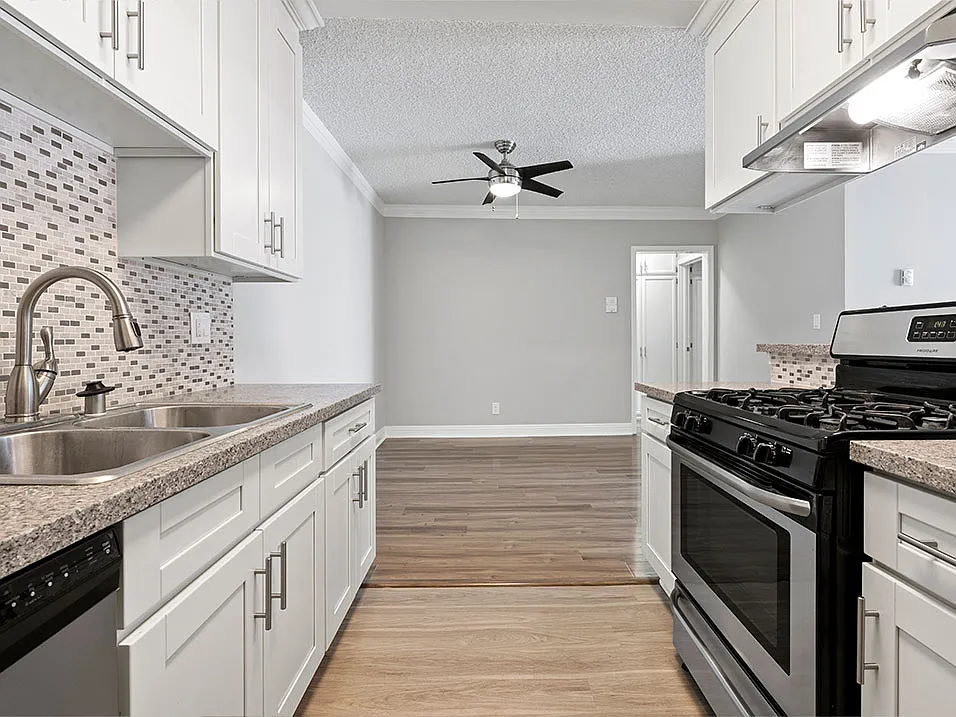 Custom tiled kitchen with stainless steel sink, oven, and fixtures.