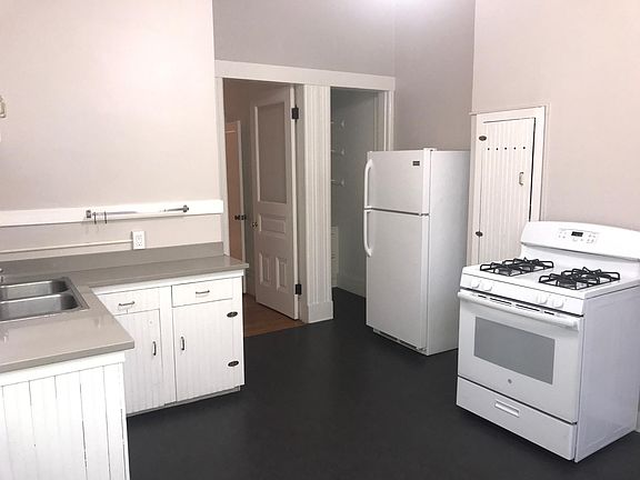 Open and airy kitchen with dining area. Leads to back porch deck and down to common laundry area, garbage collection and back courtyard.