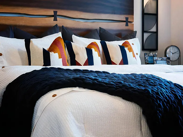 Thoughtfully Designed Bedroom with Colorful Pillows and Custom Wood Headboard