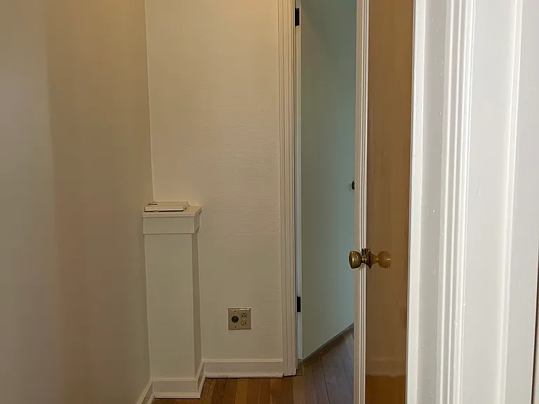Rear of hallway with hallway closet at right and laundry chute at left