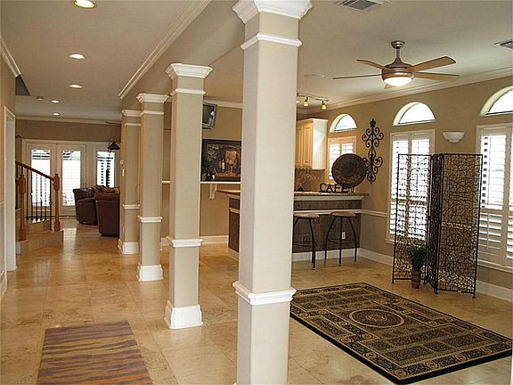 Impress your most discriminate guests! Stunning foyer boasts travertine flooring, stately columns, crown millwork, & winding iron staircase!