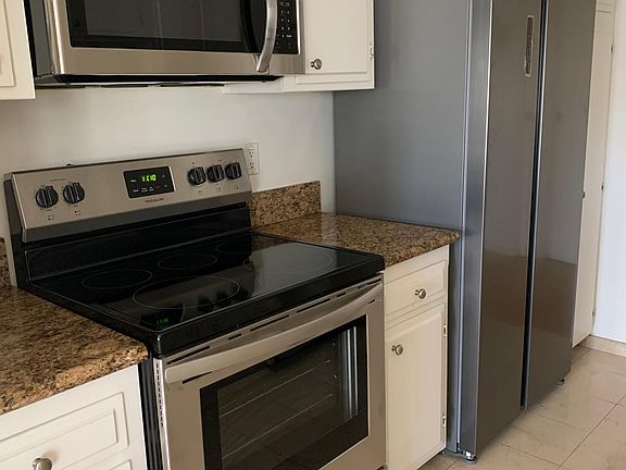 New stainless steel appliances, oven, microwave, dishwasher, and refrigerator.
