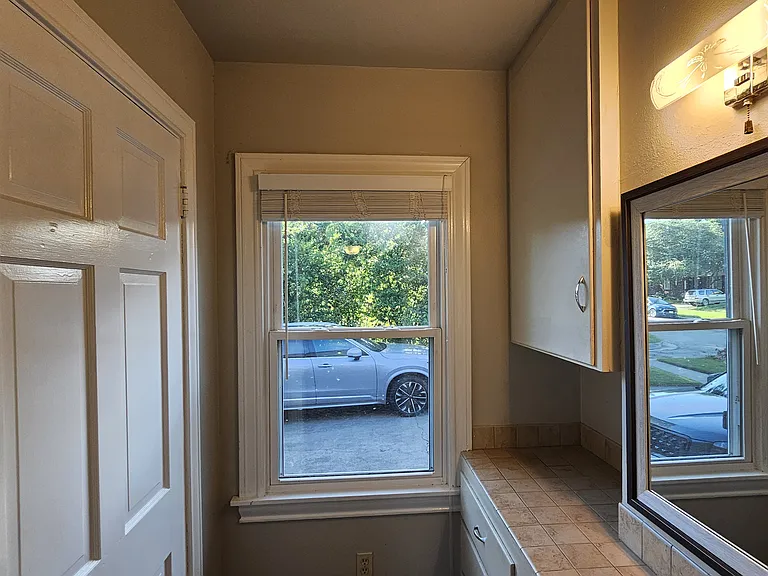 Powder nook, with access to a walk-in closet and view of the driveway.