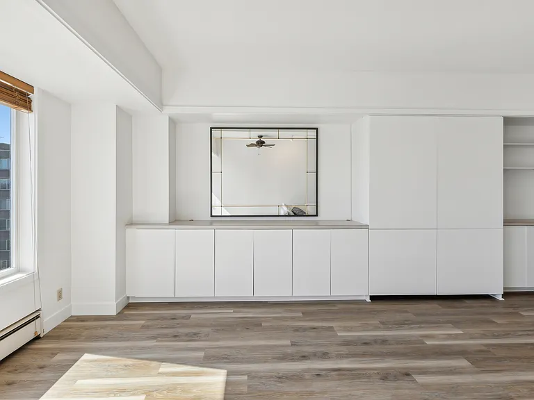 Living room with built in cabinets, shelves and murphy bed.