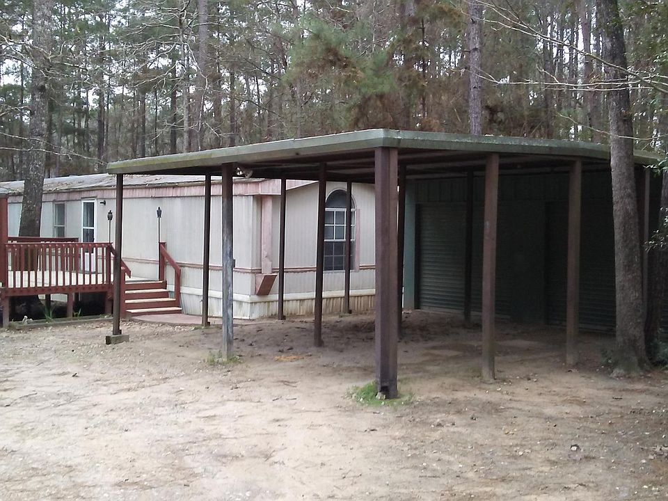 Front of property from driveway with carport storage and parking.