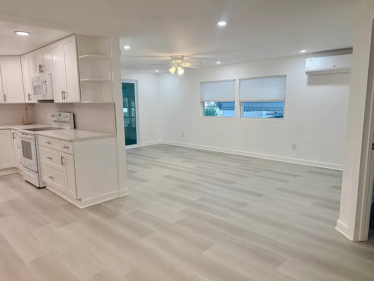 Living room leads to Florida room through sliders