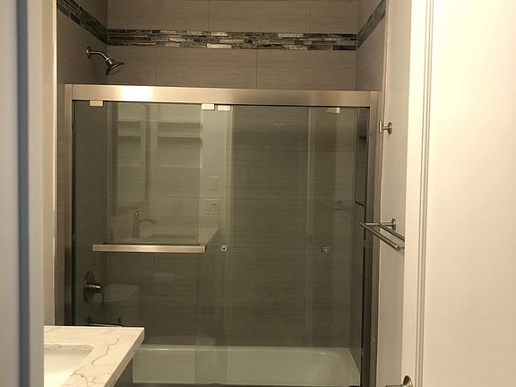 well designed bathroom with inset shelving, hook/bar hardware, matching quartz countertop and gray soft-close cabinetry