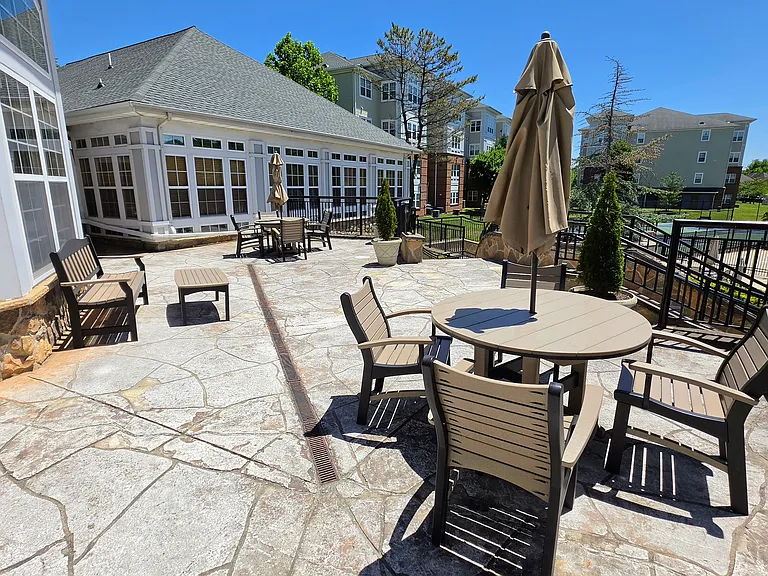 Expansive flagstone patio terrace equipped with outdoor dining tables and umbrellas, ideal for seasonal relaxing.