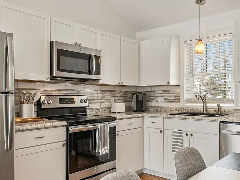 Granite Countertops White Shaker Cabinets Decorative Backsplash Electric Range Built-in Microwave Dishwasher Under-mount Sink