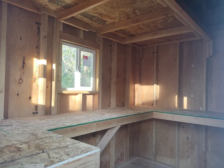 Storage Bldg shelving wraps around interior. Upper and lower