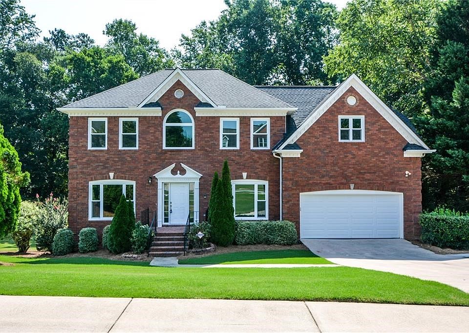 Brick beauty in Johns Creek; New windows sparkle in front of the professionally landscaped yard that frames the house.