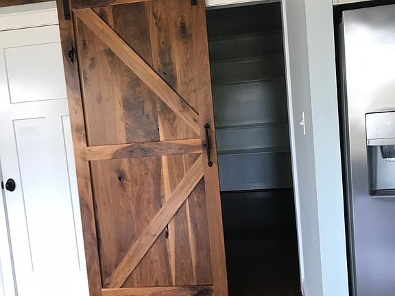 Large walk in pantry with space for additional fridge with ice maker hookup. Lots of electrical outlets for small appliances. White door to left leads to walk-in attic