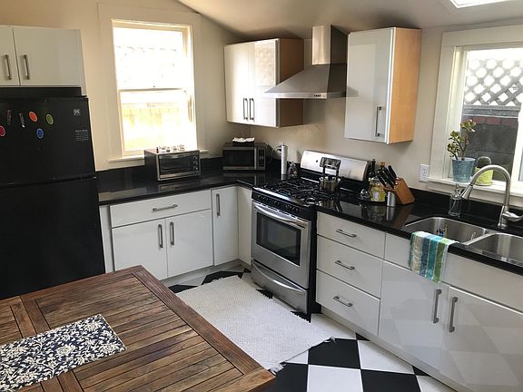 Bright modern kitchen with skylight, quartz countertops, custom cabinets and gas stove
