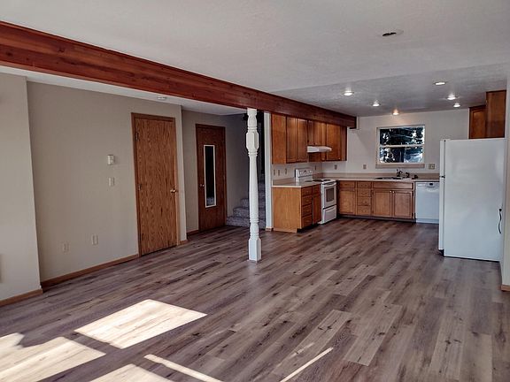 view of utility room door, bathroom door (with mirror) and kitchen from NE corner of livingroom.