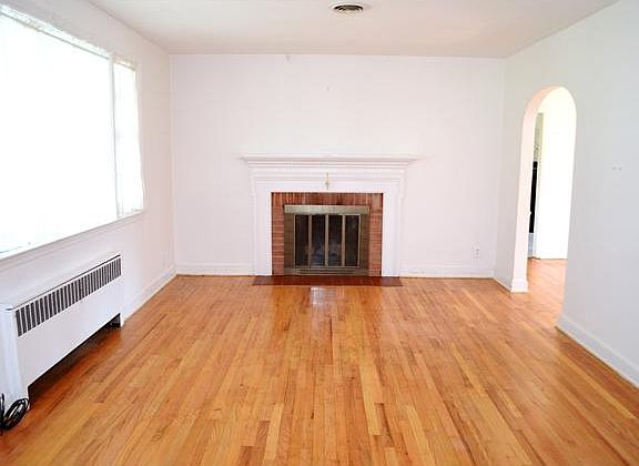 Brick fireplace and large window in living room