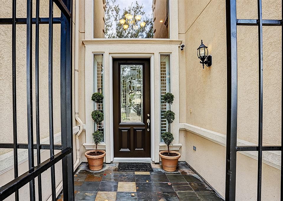 Private Courtyard entry with tall leaded glass front door. Slate tile, plantation shutters in side lights. Notice fabulous chandelier in the entry. Welcome home!