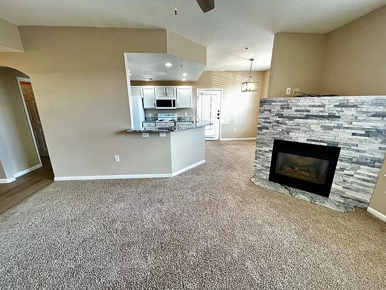 Living room looking back at the kitchen with hallway (left) leading to first bedroom with ensuite bathroom.