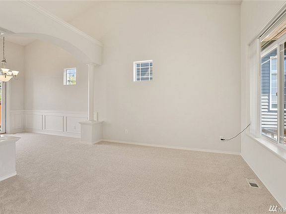 Formal Living Room and Formal Dining Room .  The cathedral ceilings and white wainscotting add elegance and class to these spaces while the huge south facing window draws loads of light in.