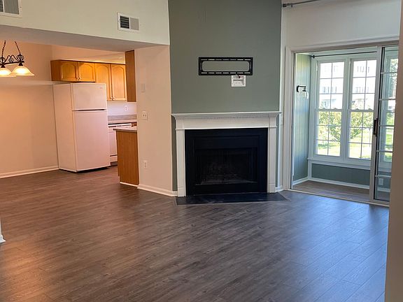 Living room has vaulted ceiling, ceiling fan, and fireplace
