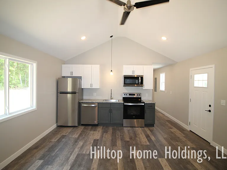 The kitchen is equipped with a range, dishwasher, refrigerator, and microwave.