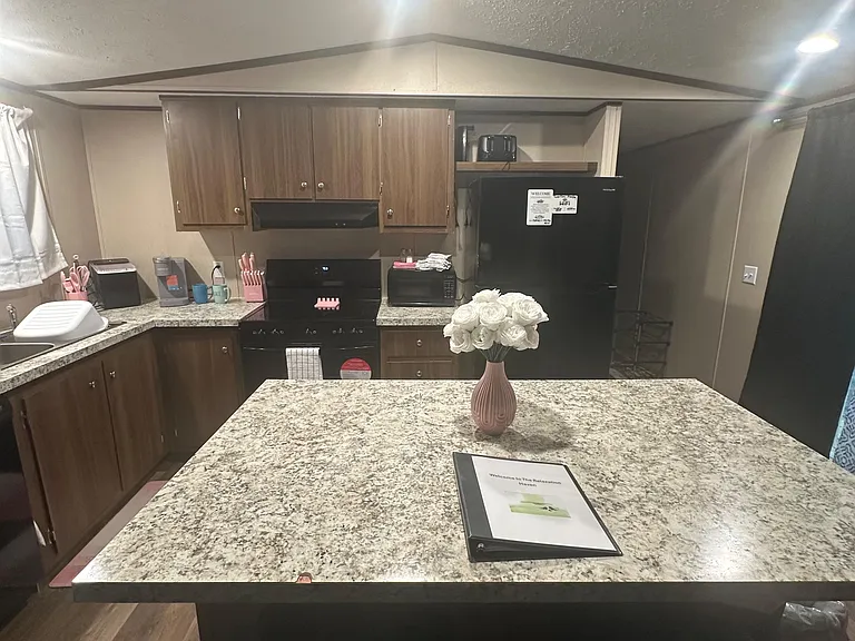 Spacious kitchen with ample cabinetry, full-size appliances, and a large breakfast bar for dining or prep.