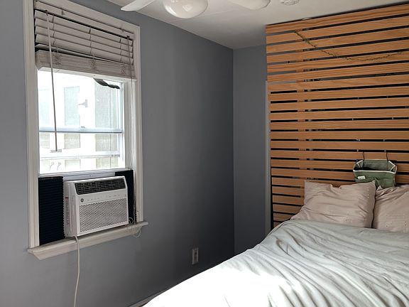 Long bedroom with modular room divider hidding walkin closet.