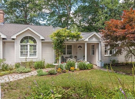 Arched windows, flag stone walkway, crushed stone driveway and covered porch create charm and elegance to this one story home.