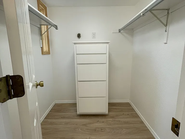 Primary bedroom's walk-in closet with built-in storage. Across from the vanity area.