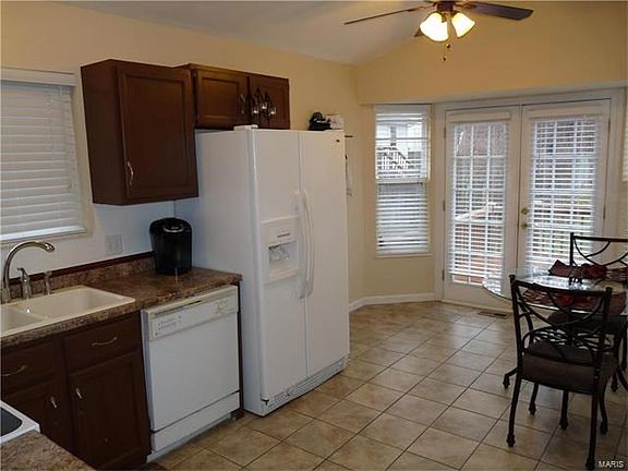 Kitchen with ceramic flooring, bay window, pantry & vaulted ceiling with plant shelving.