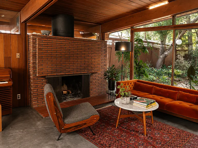 Original brick fireplace anchoring the living room - A Quincy Jones signature