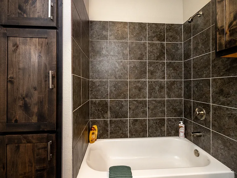 Bathroom 1 is located on the first floor and has a tub/shower combo with cabinet sink and mirror.