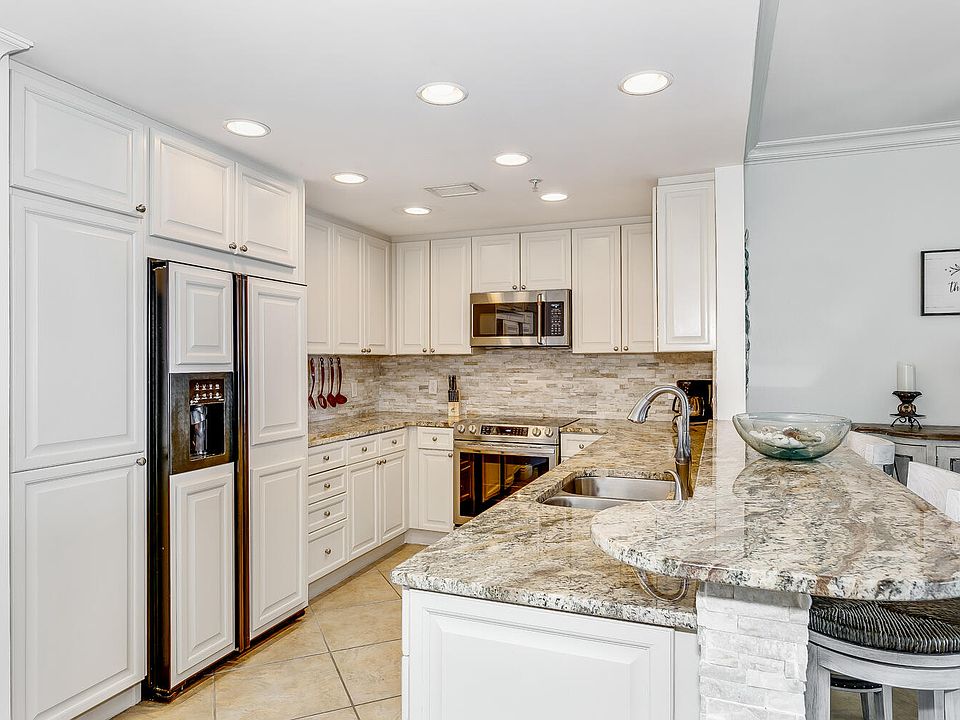 UPDATED KITCHEN WITH SPECIALTY STONE BACKSPLASH, CABINET FACED REFRIGERATOR, GORGEOUS GRANITE